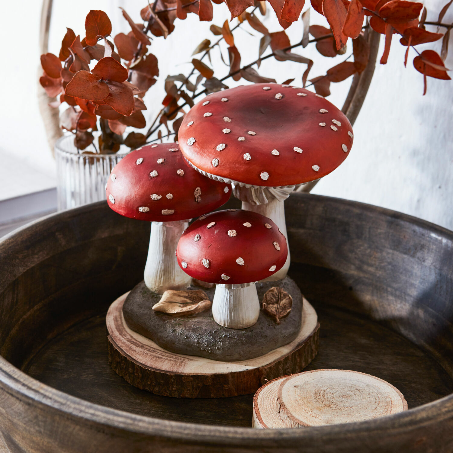 Decoratieve rode paddenstoelen met witte stippen op houten voet voor herfstige interieurdecoratie