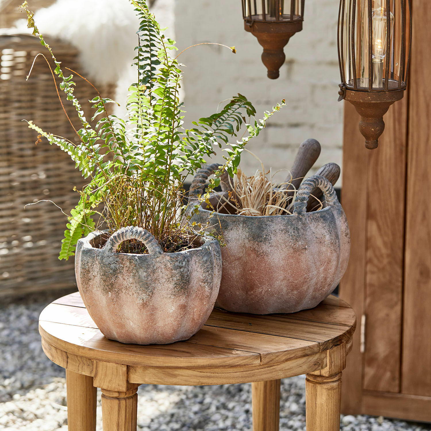 Twee terracotta kleurige keramische bloempotten met handvatten op houten tafel, tuindecoratie