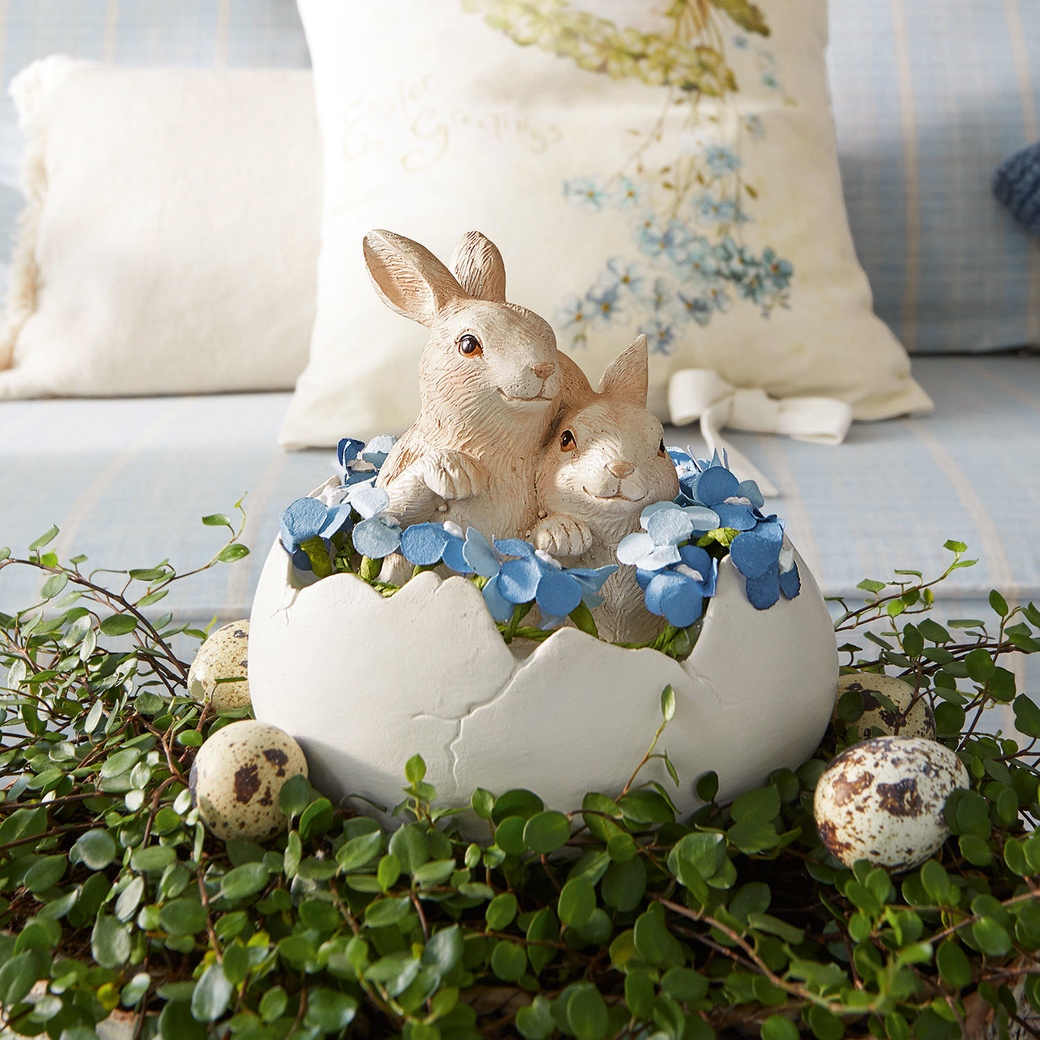 Hazen met ei Miksa Decoratie met twee konijnen in een witte eierschaal, blauwe bloemen en groen blad