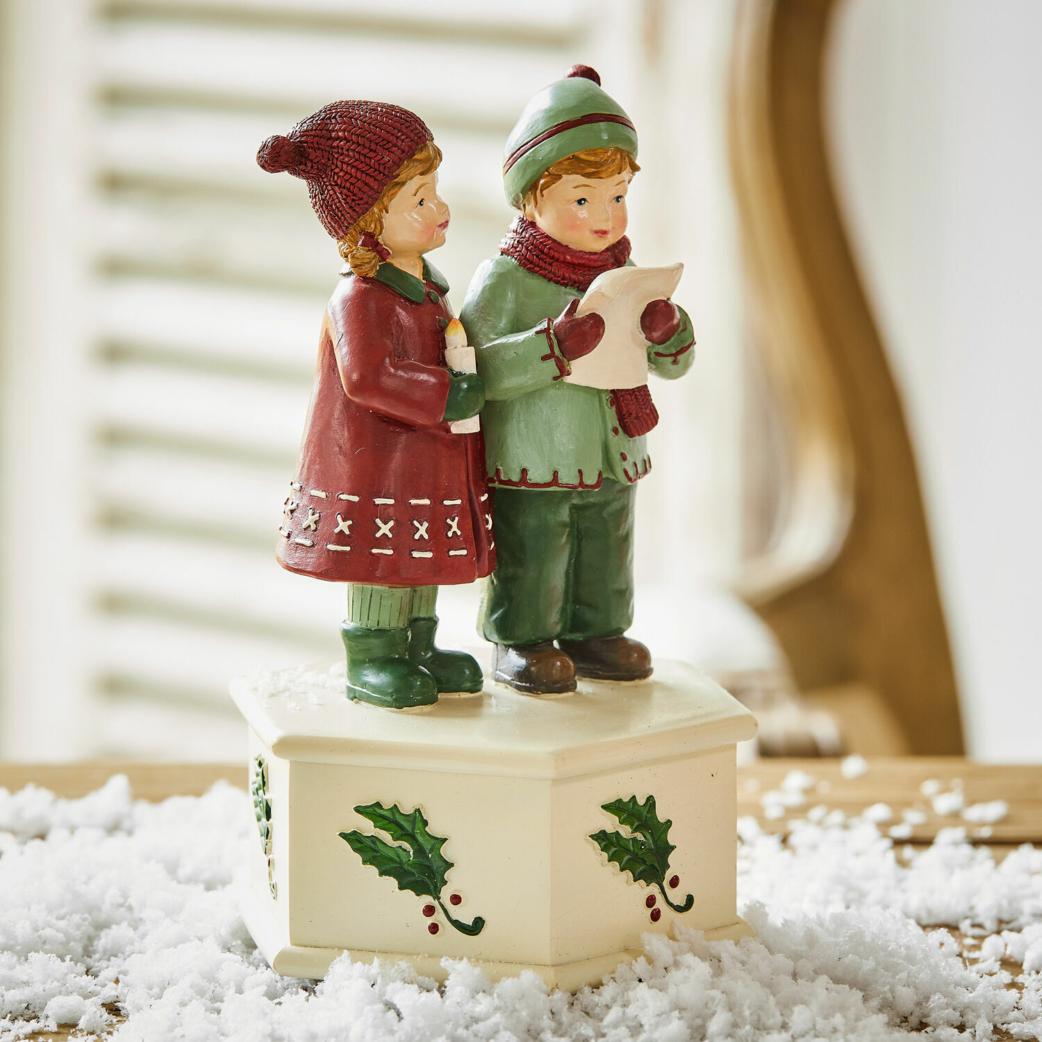 Beeldje van zingende kinderen op crèmekleurige voet met hulstmotief, kerstdecoratie