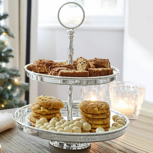 Tweeledig zilveren etagère voor koekjes en snoep op houten tafel met kerstdecoratie