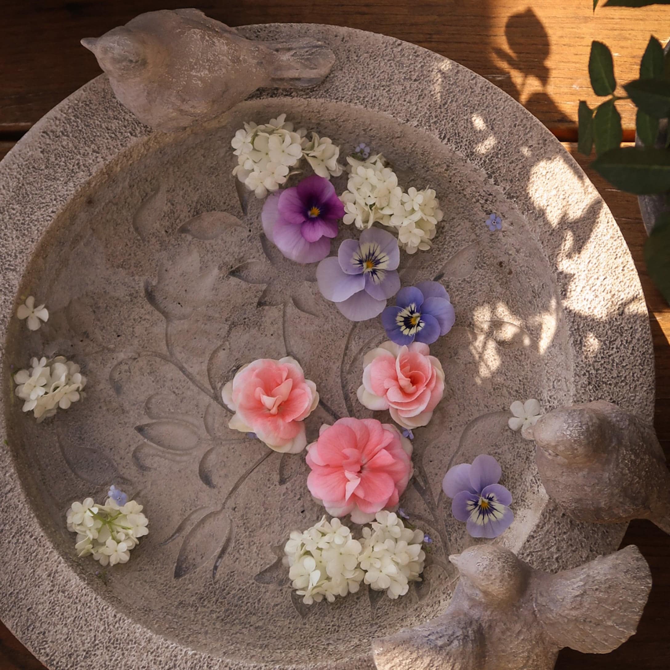 Decoratieve stenen schaal met vogel- en bloemmotief, geschikt voor tuin- of woondecoratie
