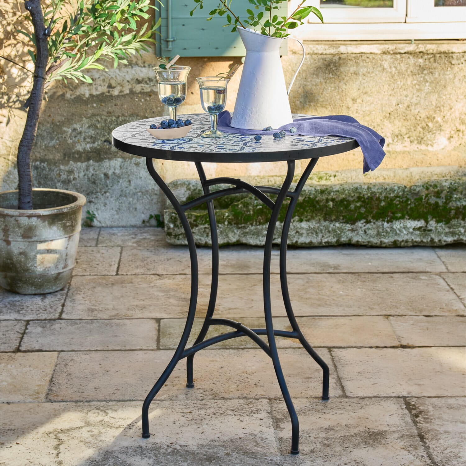 Tafel Giulessa Ronde tuintafel met zwart metalen onderstel en blauw-wit mozaïek tafelblad buiten