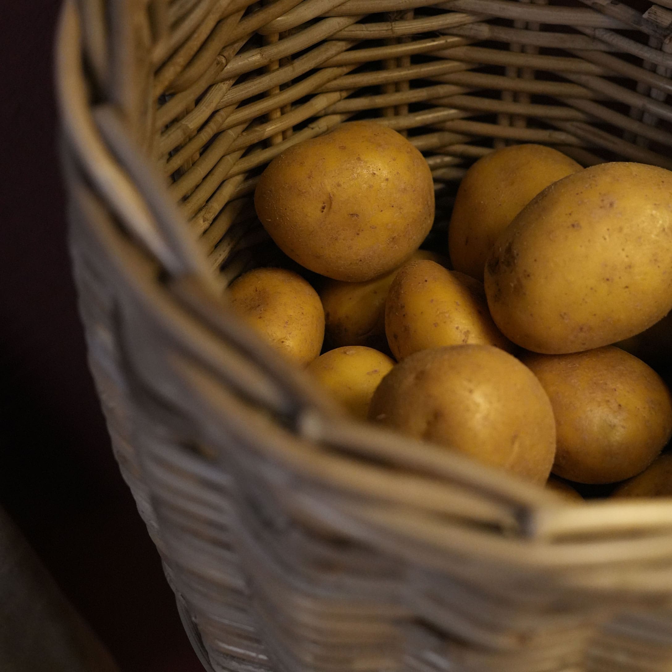 Verse aardappelen in een natuurlijke rieten mand, groenten voor de keuken