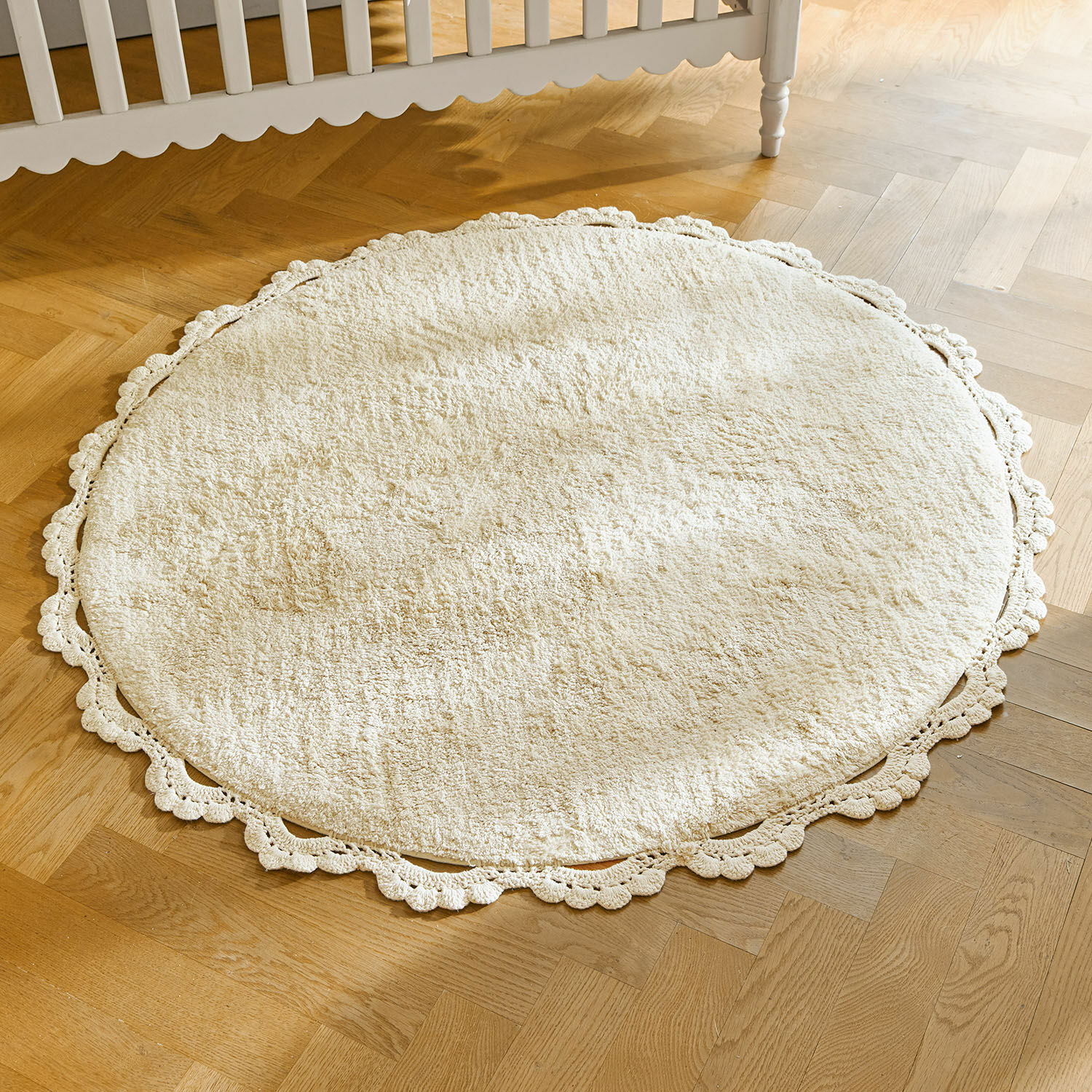 Vloerkleed Arash Ronde crèmekleurige vloerkleed van zacht materiaal met decoratieve kanten rand op houten vloer