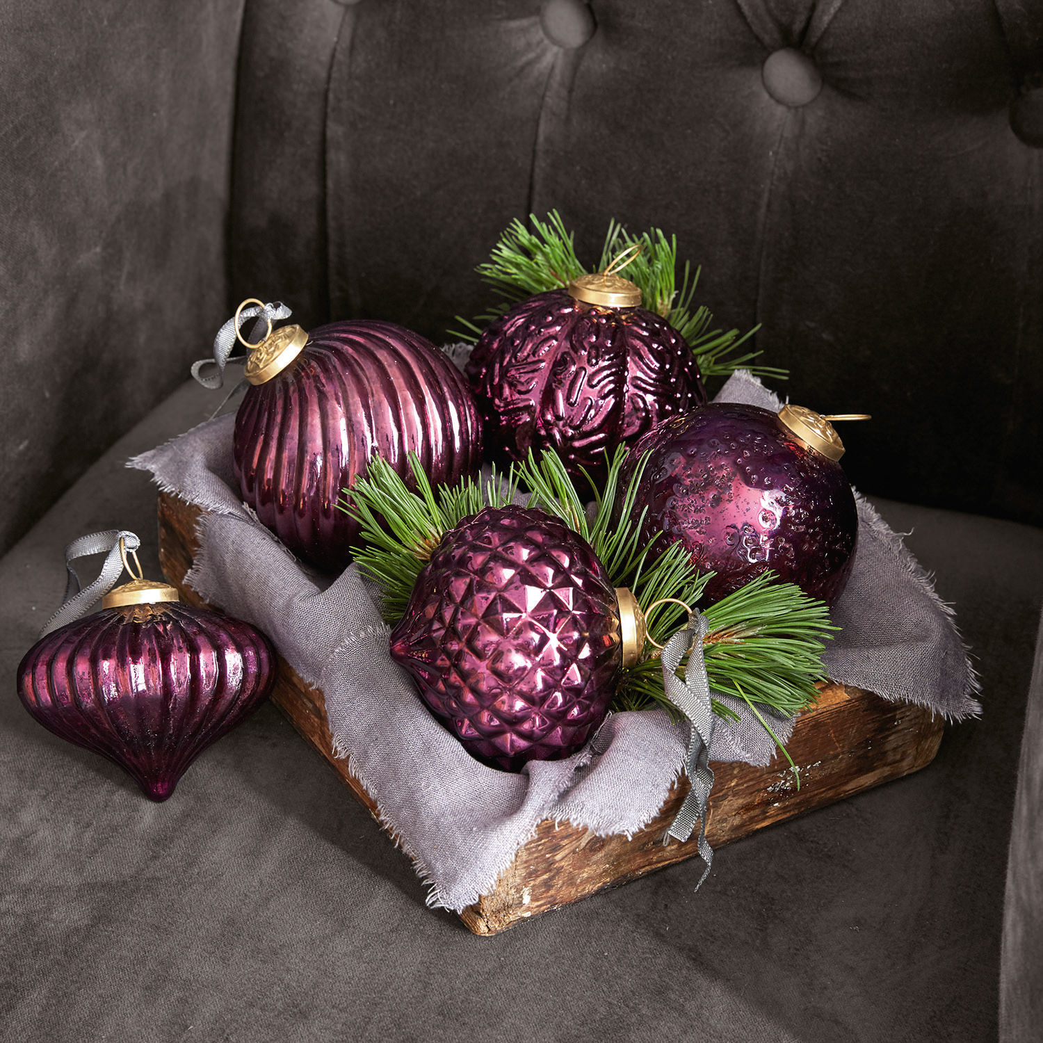 Kerstversiering, set van 5 Sambre Set paarse glazen kerstballen met groene takken in houten bak op grijze achtergrond