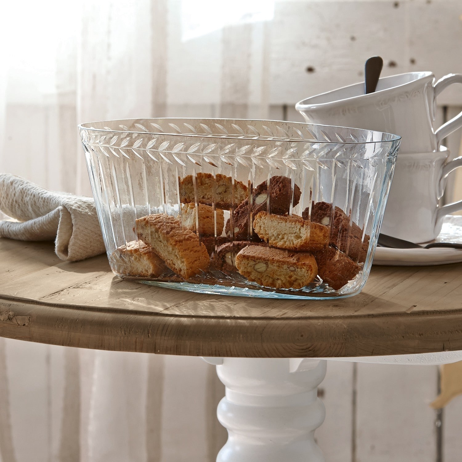Schaal Malinda Transparante glazen schaal met decoratief patroon gevuld met koekjes op lichte houten tafel
