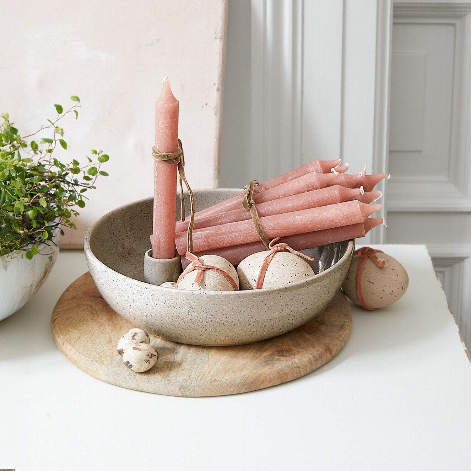 Set roze kaarsen en beige keramische decoraties in kom op houten plank