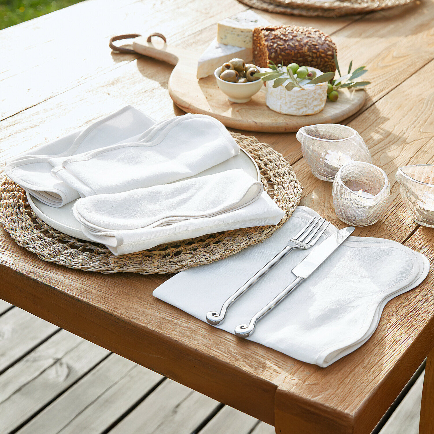 Set witte linnen servetten en tafelkleden op houten tafel met mes en vork