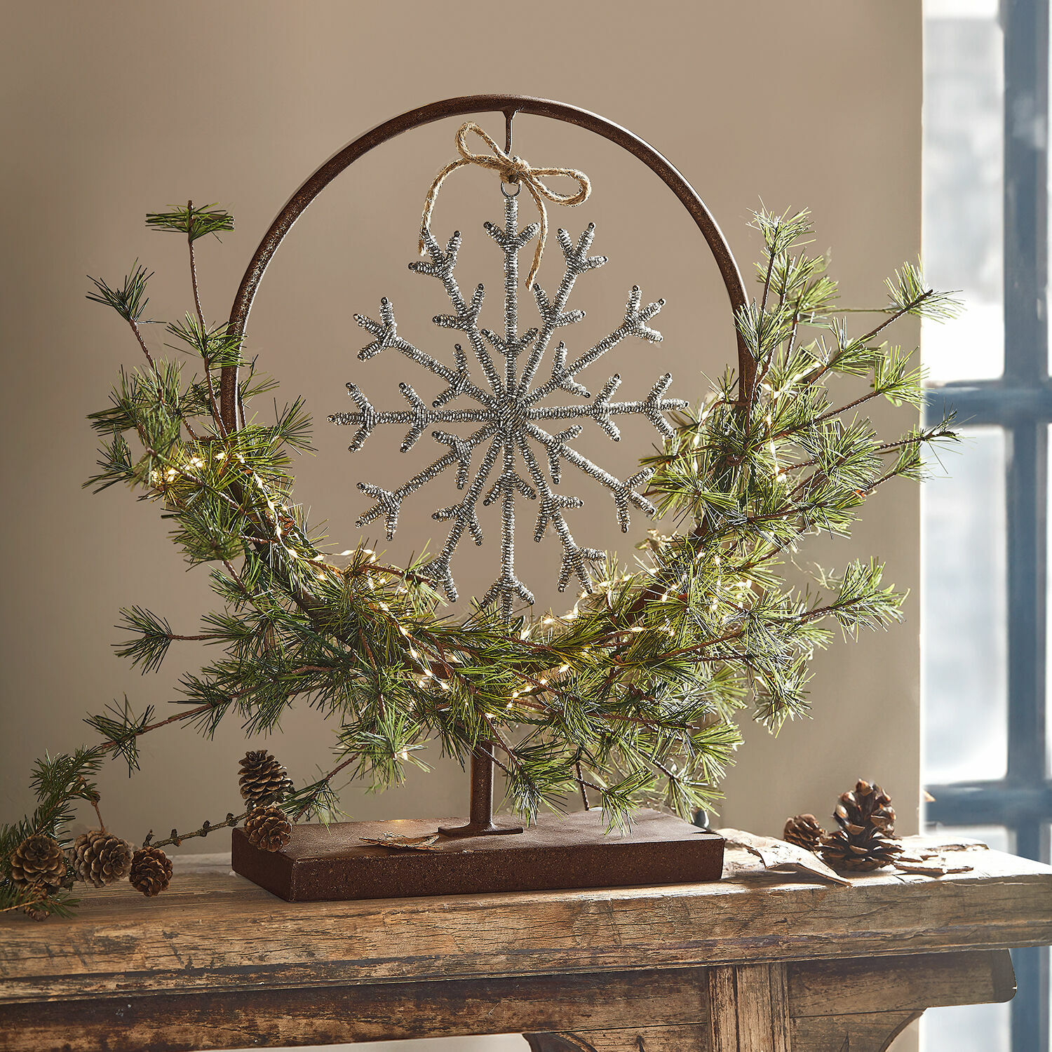 Sierstandaard Nélivanne Kerstdecoratie met metalen standaard, zilveren sneeuwvlok, groene takken en dennenappels op houten voet