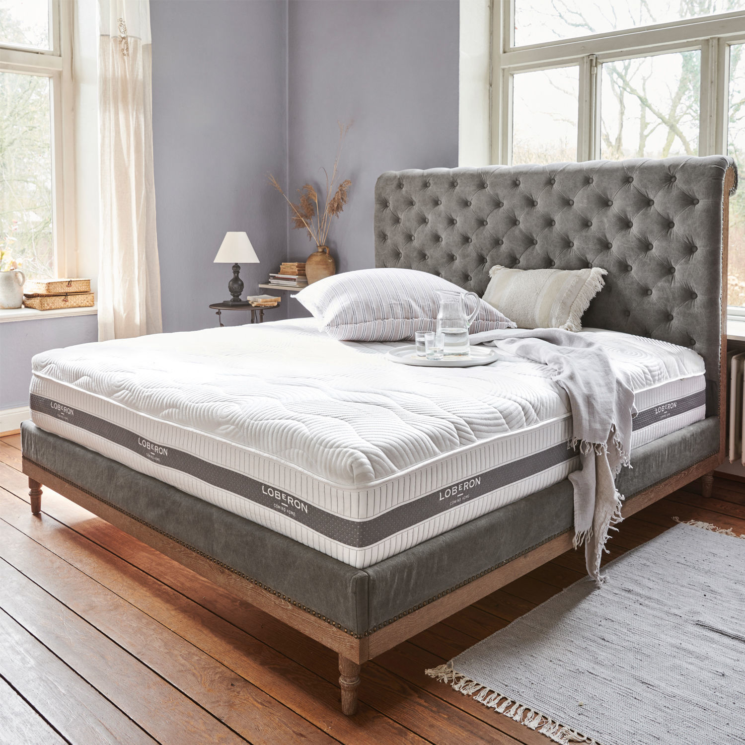 Matras met topper 180x200 Raillimont Gestoffeerd bed met grijs doorgestikt hoofdeinde en wit Loberon matras in lichte slaapkamer