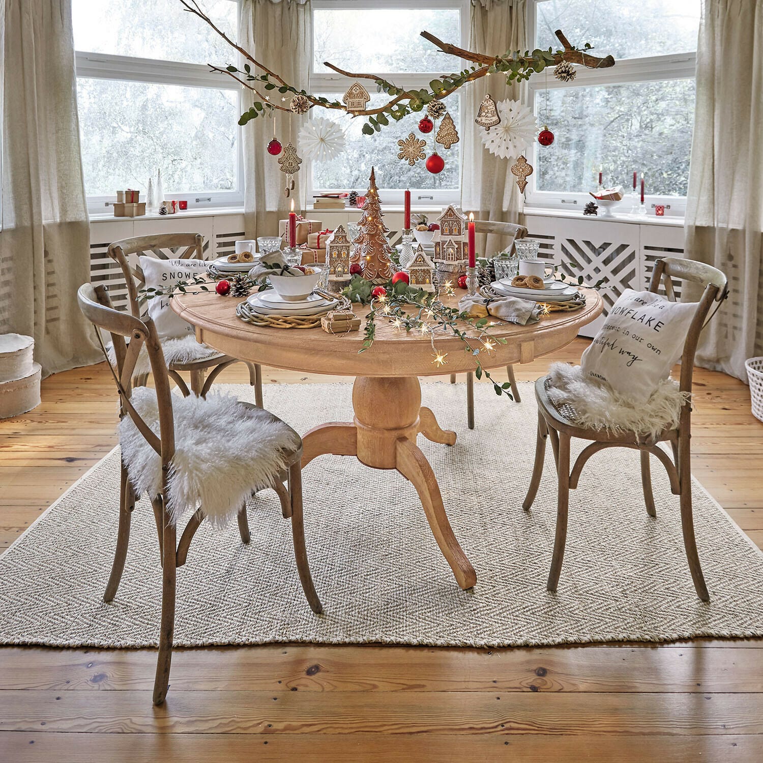 Tafel Beaumont Ronde eettafel van licht hout met beige stoelen en decoraties in een lichte eetkamer