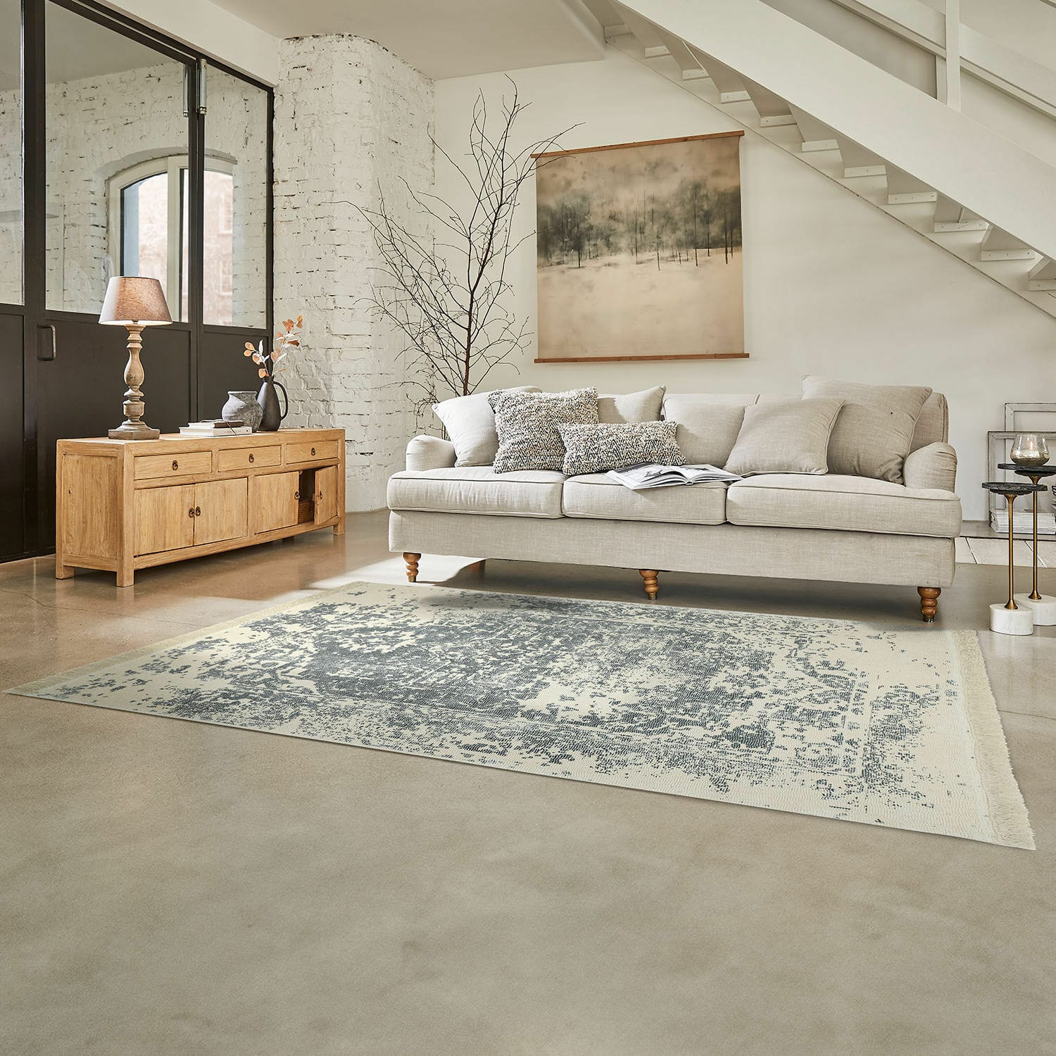 Vloerkleed Lortet Beige bank met kussens en lichte houten dressoir in lichte woonkamer met vintage vloerkleed