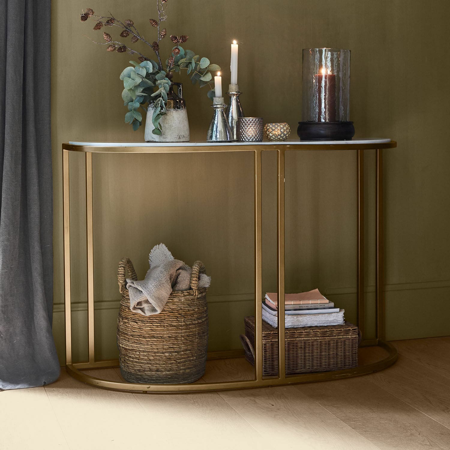Wandtafel Soréline Consoletafel met wit marmeren blad en gouden metalen frame, gedecoreerd met kaarsen en vaas met groene bladeren