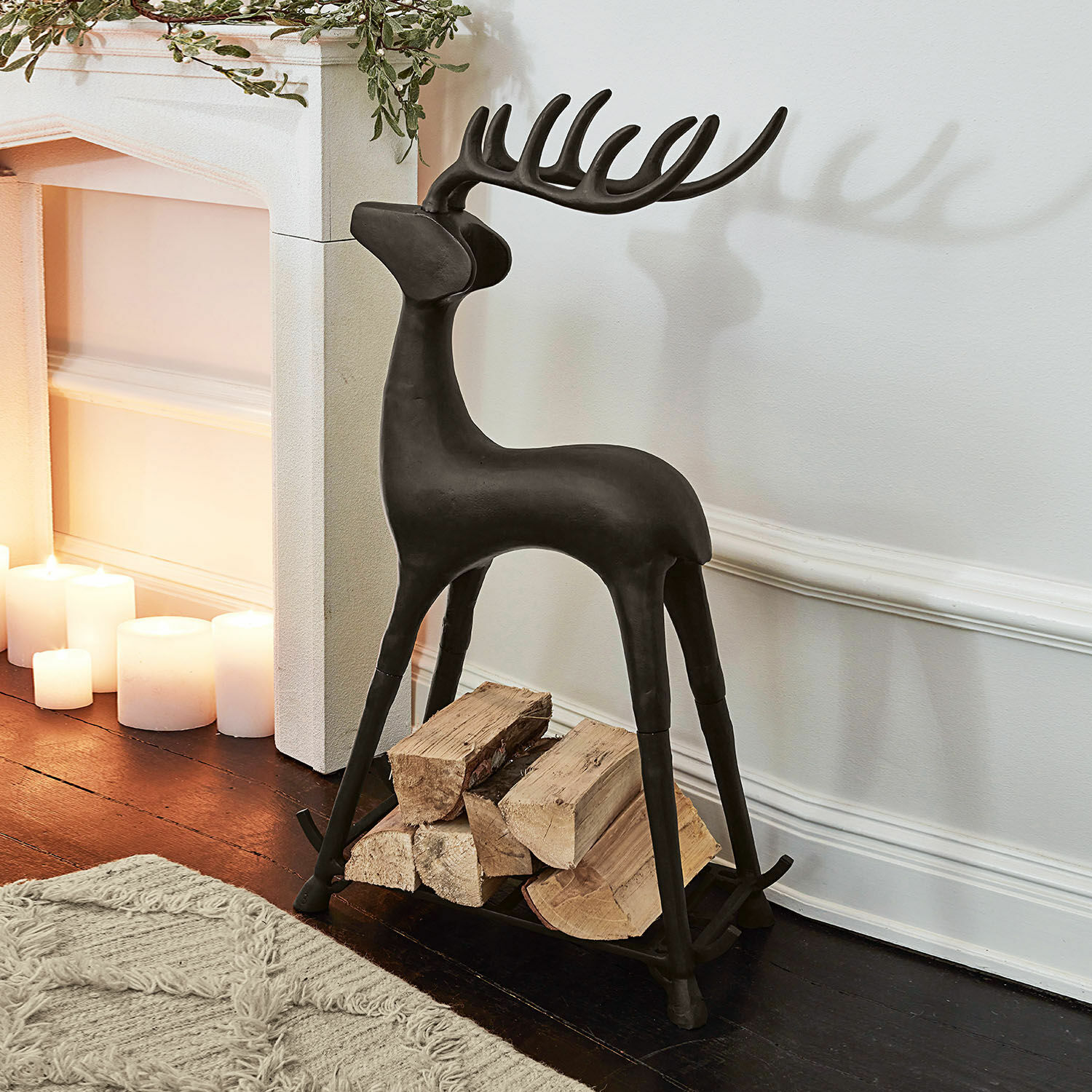 Zwarte metalen houtdrager in hertvorm, decoratief en praktisch voor open haardhout