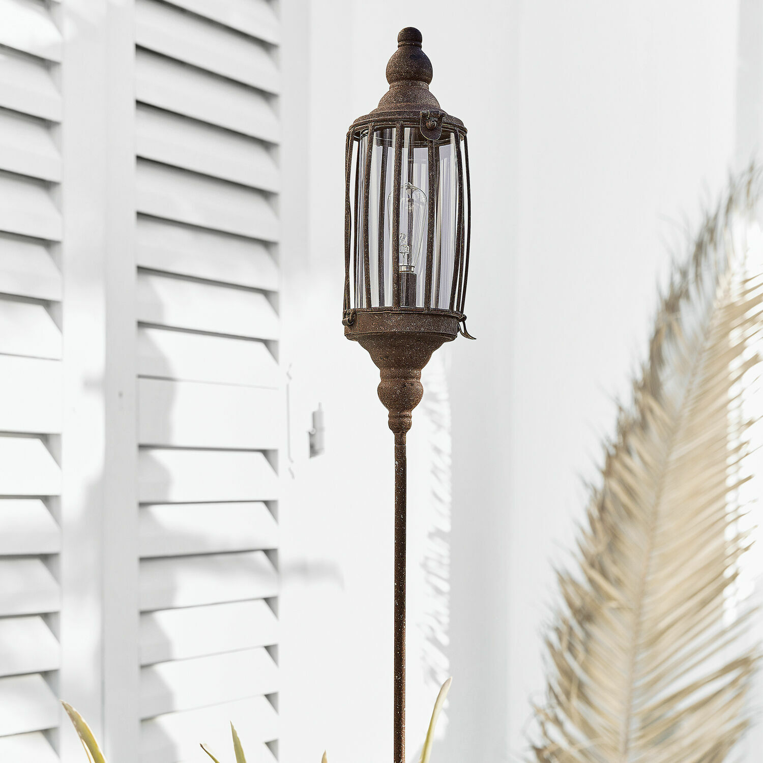 Decoratieve tuinlamp van metaal in roestkleur, ideaal voor buitenverlichting en decoratie.