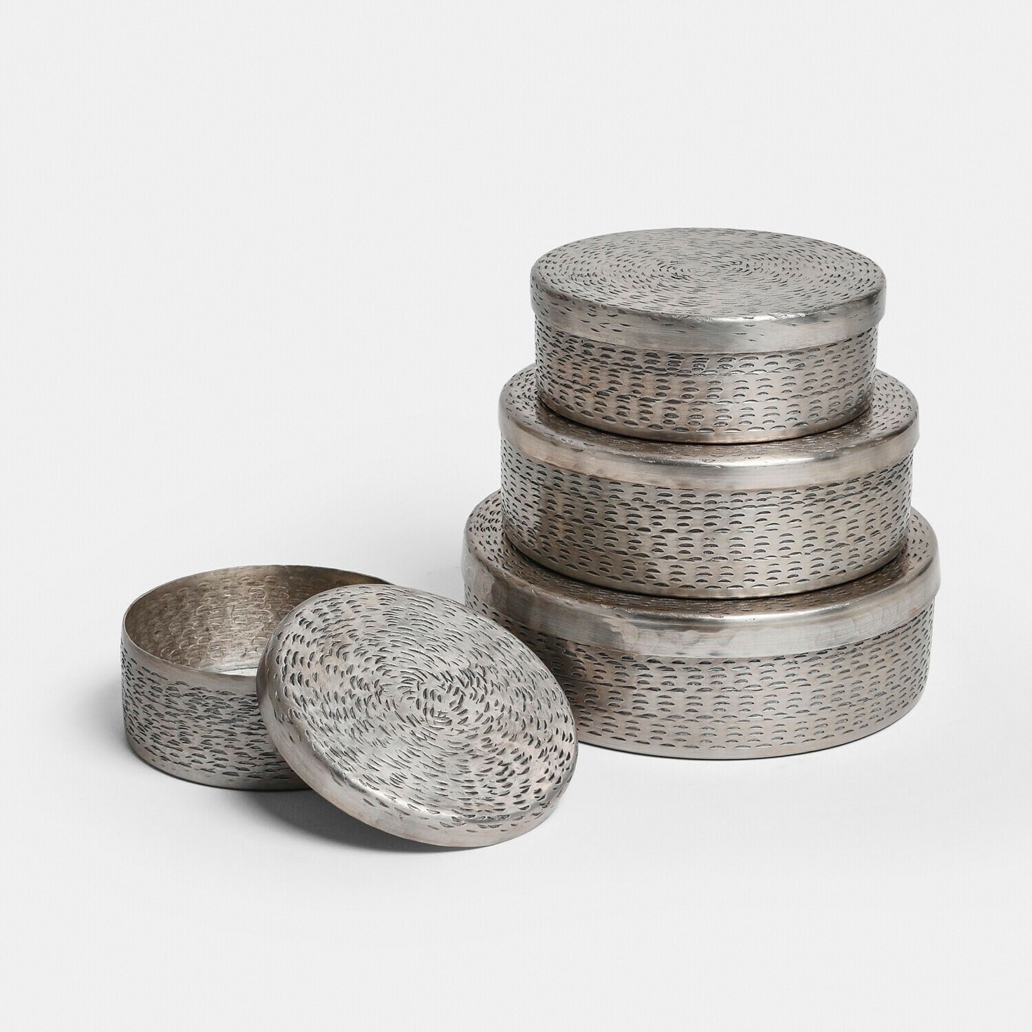 Set van drie ronde metalen dozen in zilver met deksels en een gestructureerd oppervlak