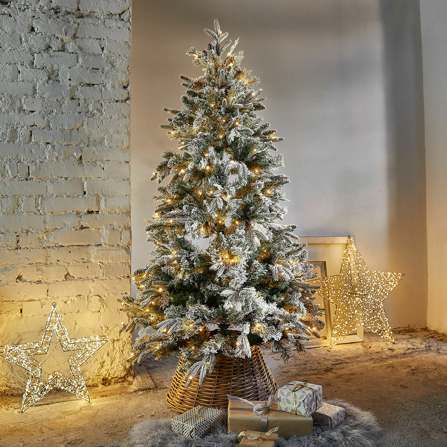 Kerstboom Cadelise Kunstkerstboom met besneeuwde takken en warme LED-verlichting in rieten standaard met cadeaus
