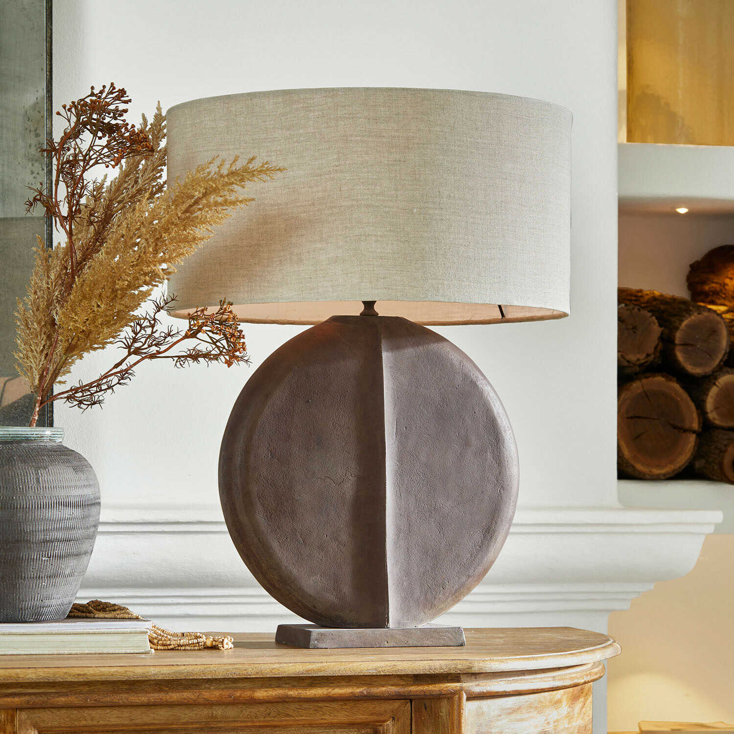 Tafellamp met ronde bruine keramische voet en beige kap voor woonkamer