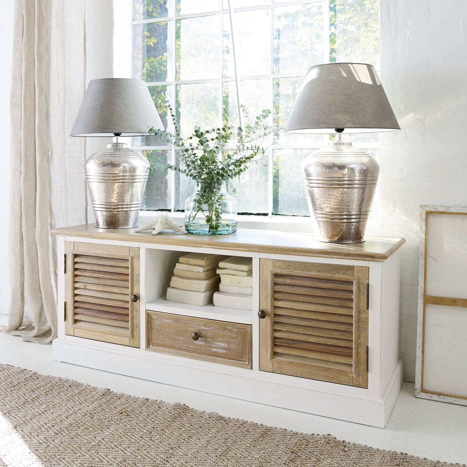 Sideboard Glencoe Witte houten dressoir met natuurlijk blad en lamellen deuren, gedecoreerd met lampen en boeken