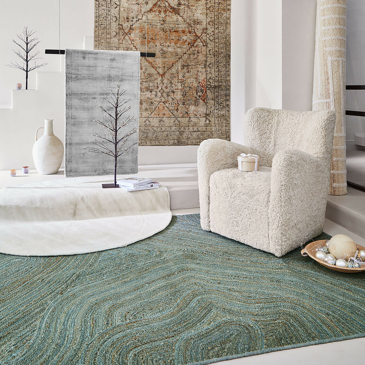 Knusse stoel van zacht crèmekleurig materiaal op groen vloerkleed in moderne ruimte