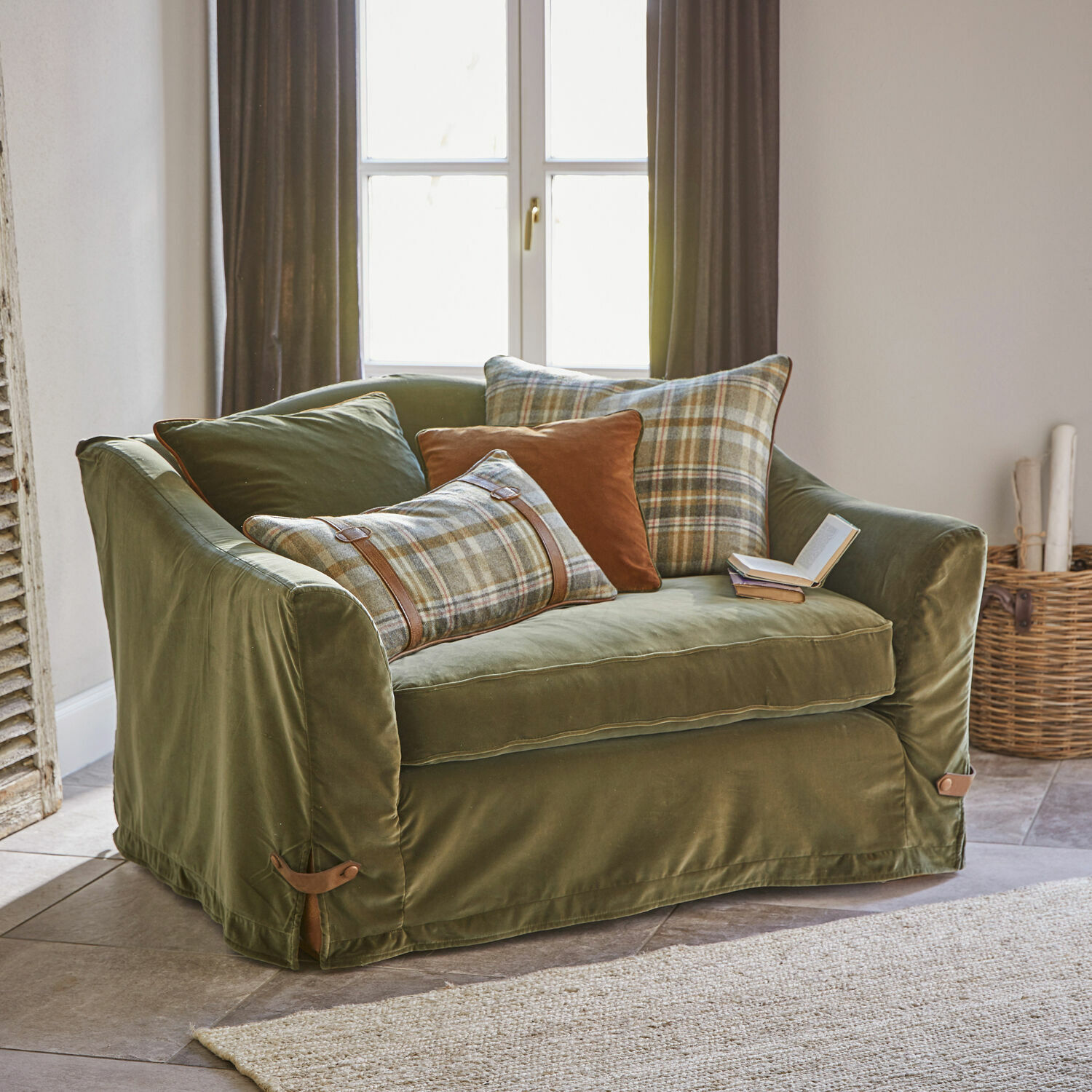 Twee-zits groene fluwelen bank met geruite kussens en bruine accenten voor woonkamer