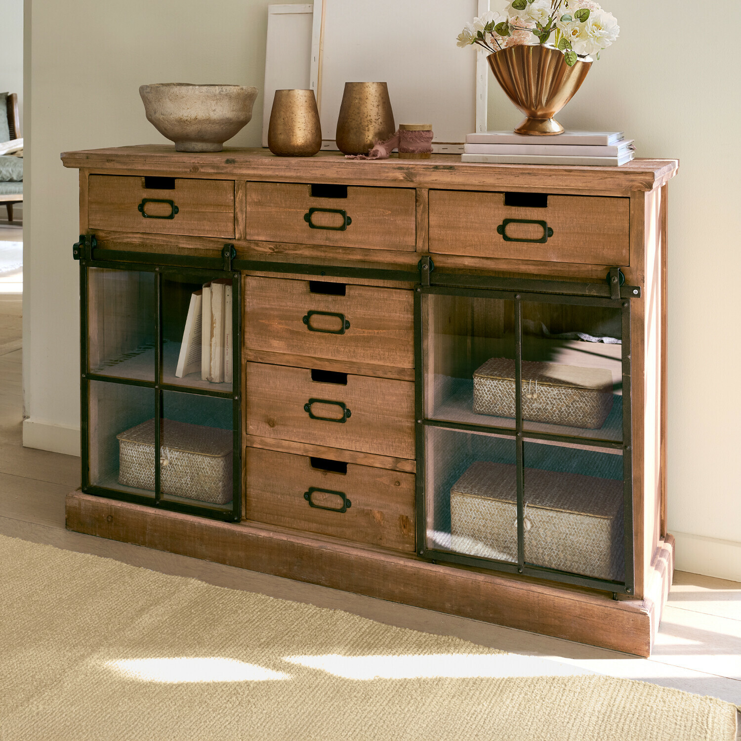 Houten dressoir met metalen schuifdeuren en lades, decoraties bovenop