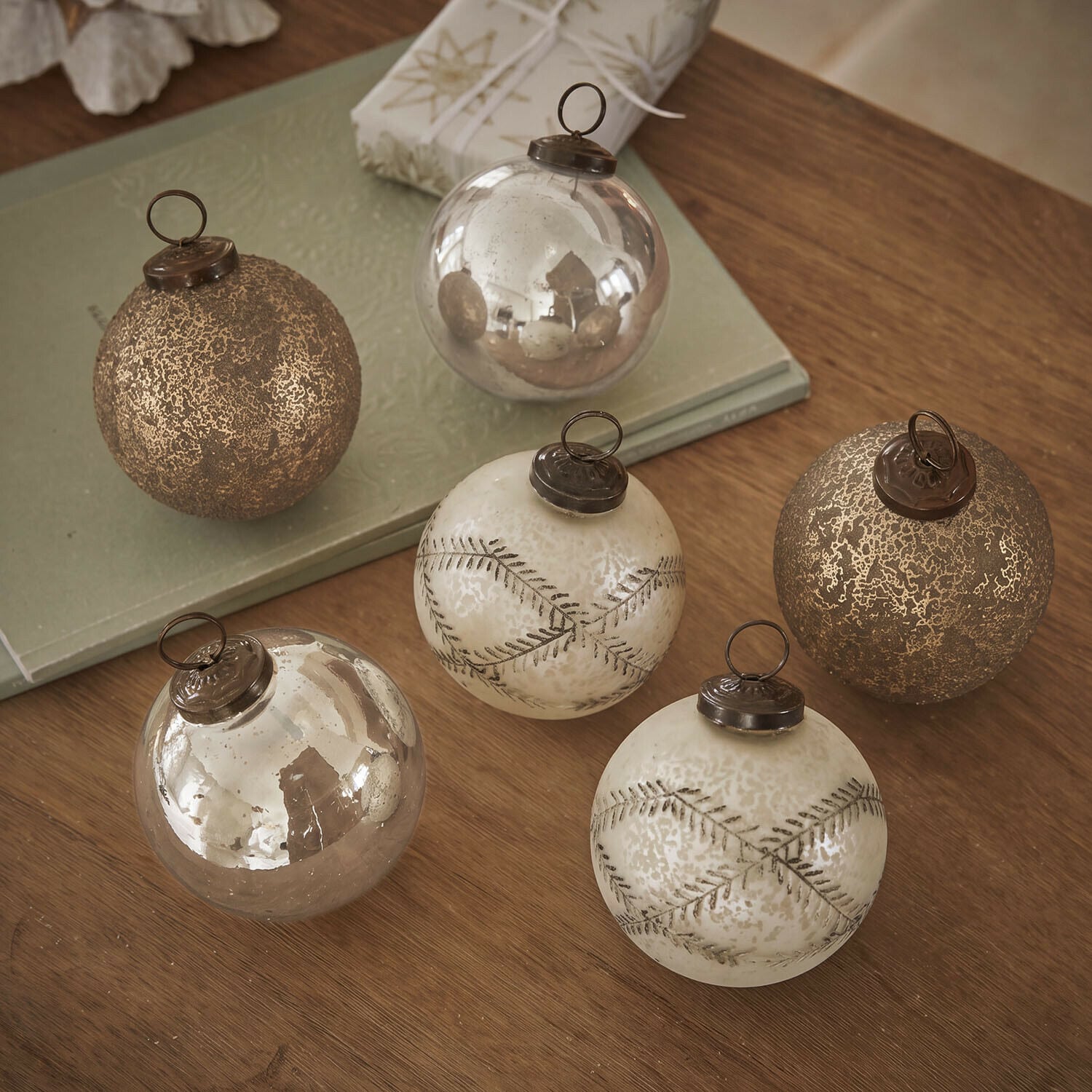 Kerstbal set van 6 Fioravino Set van zes gouden glazen kerstballen met verschillende texturen op een houten tafel