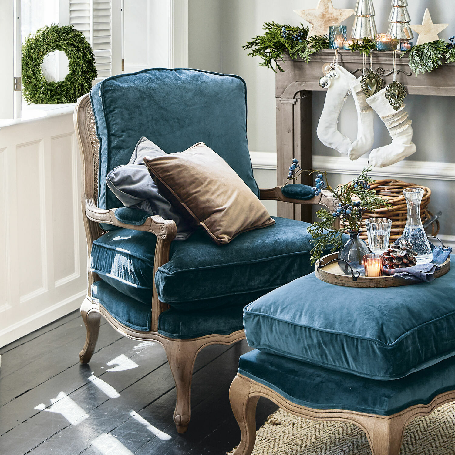 Comfortabele fauteuil en voetenbank van blauw fluweel met houten frame in klassieke stijl