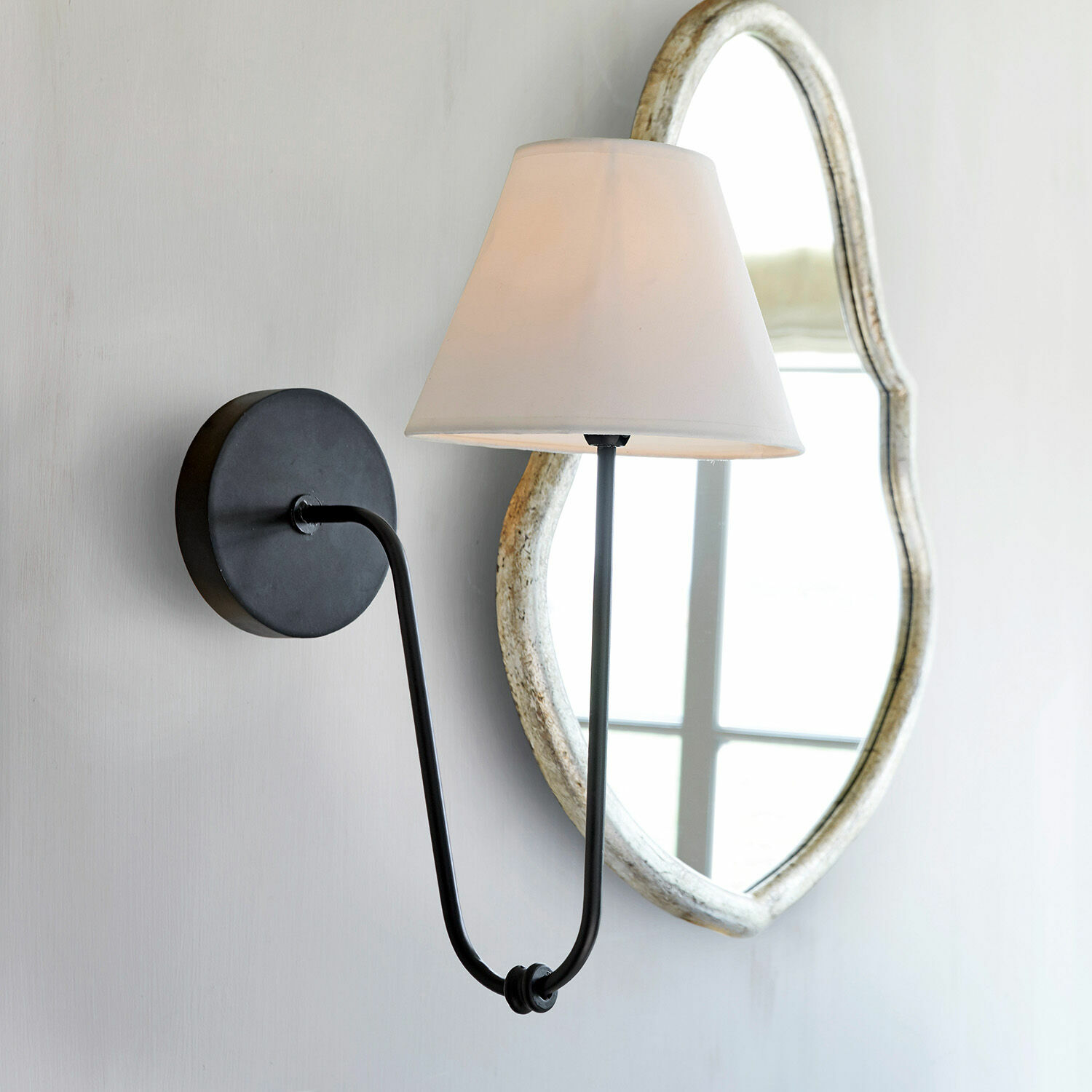 Wandlamp Lustre Zwarte metalen wandlamp met witte kap en decoratieve spiegel op de achtergrond, wandverlichting