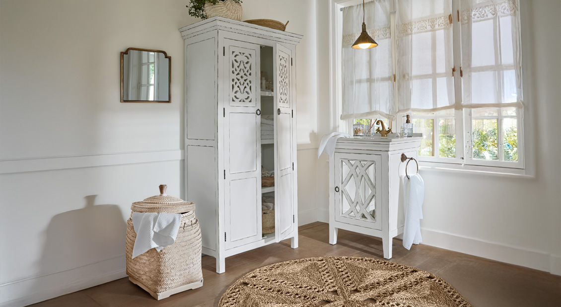 Witgewassen houten kast en wastafel in lichte badkamer met natuurlijke accenten