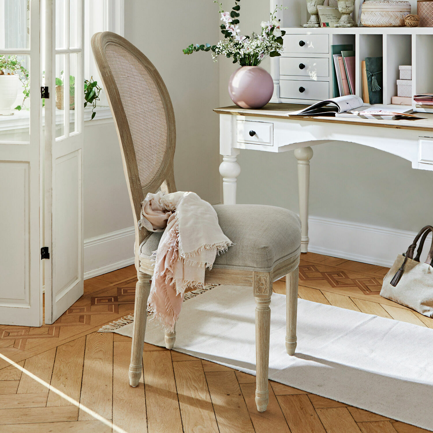 Elegante stoel van licht hout met beige bekleding in stijlvolle kamer met wit bureau