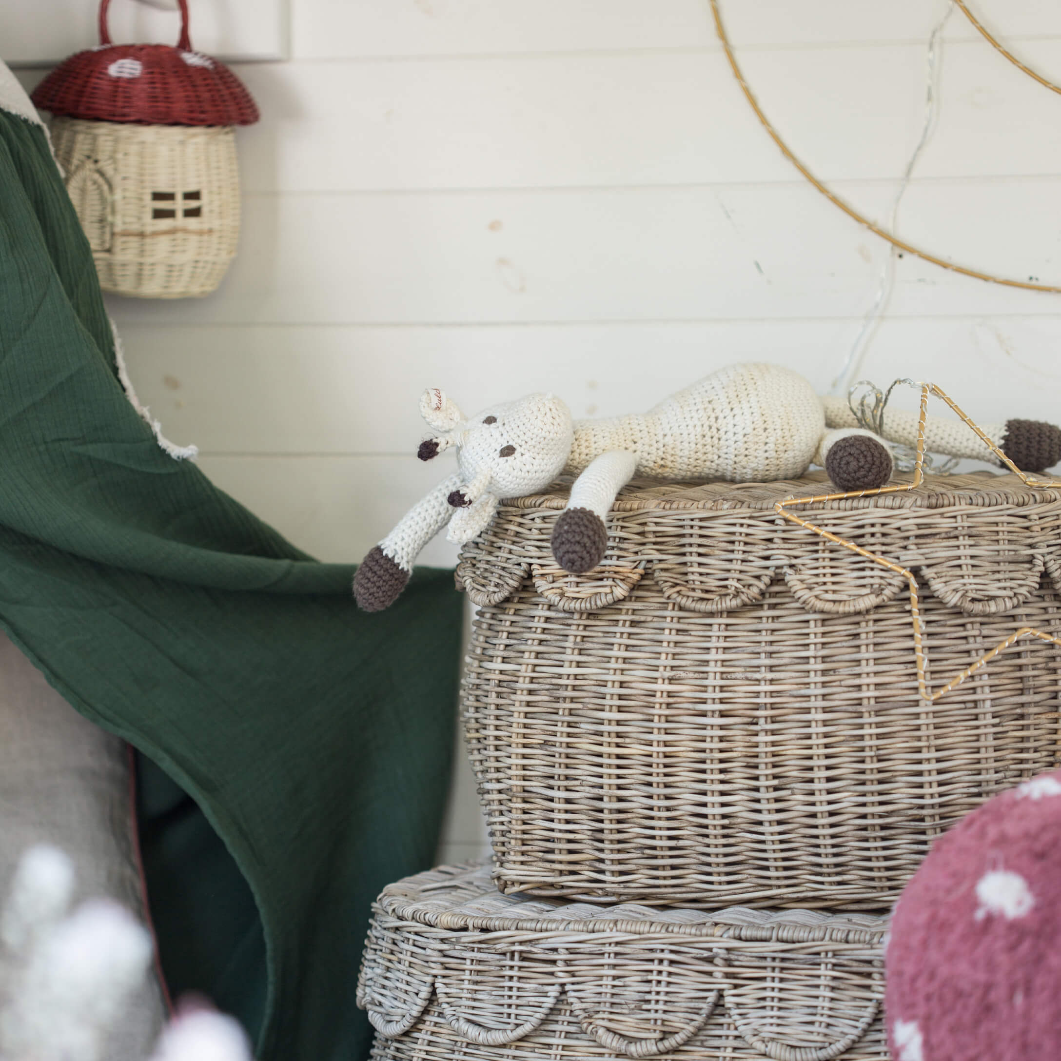 Met de hand gehaakte witte en bruine giraf op een decoratieve rieten mand in boho-stijl