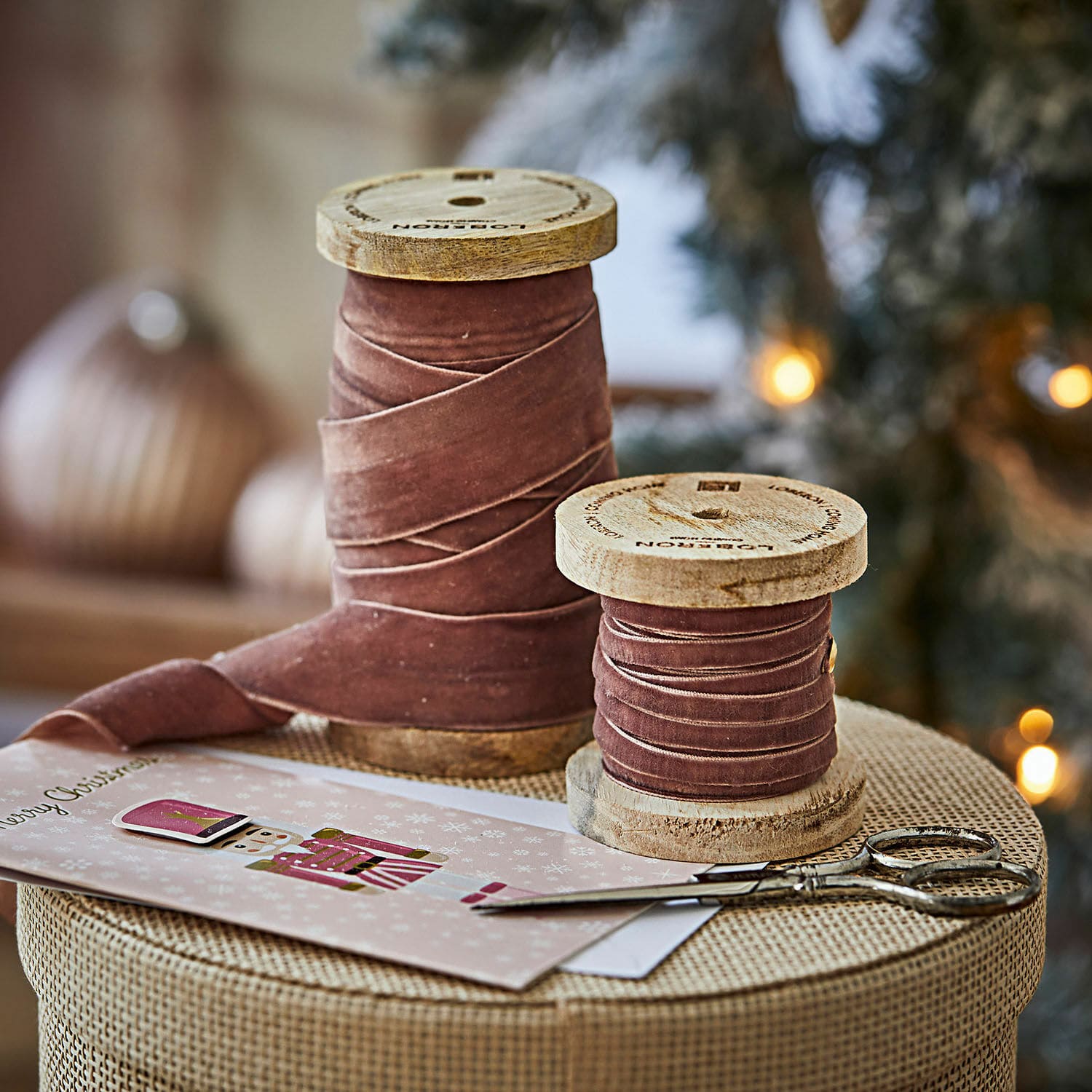 Fluwelen lint set van 2 Liandis Twee houten spoelen met roze fluwelen lint op kersttafel met schaar