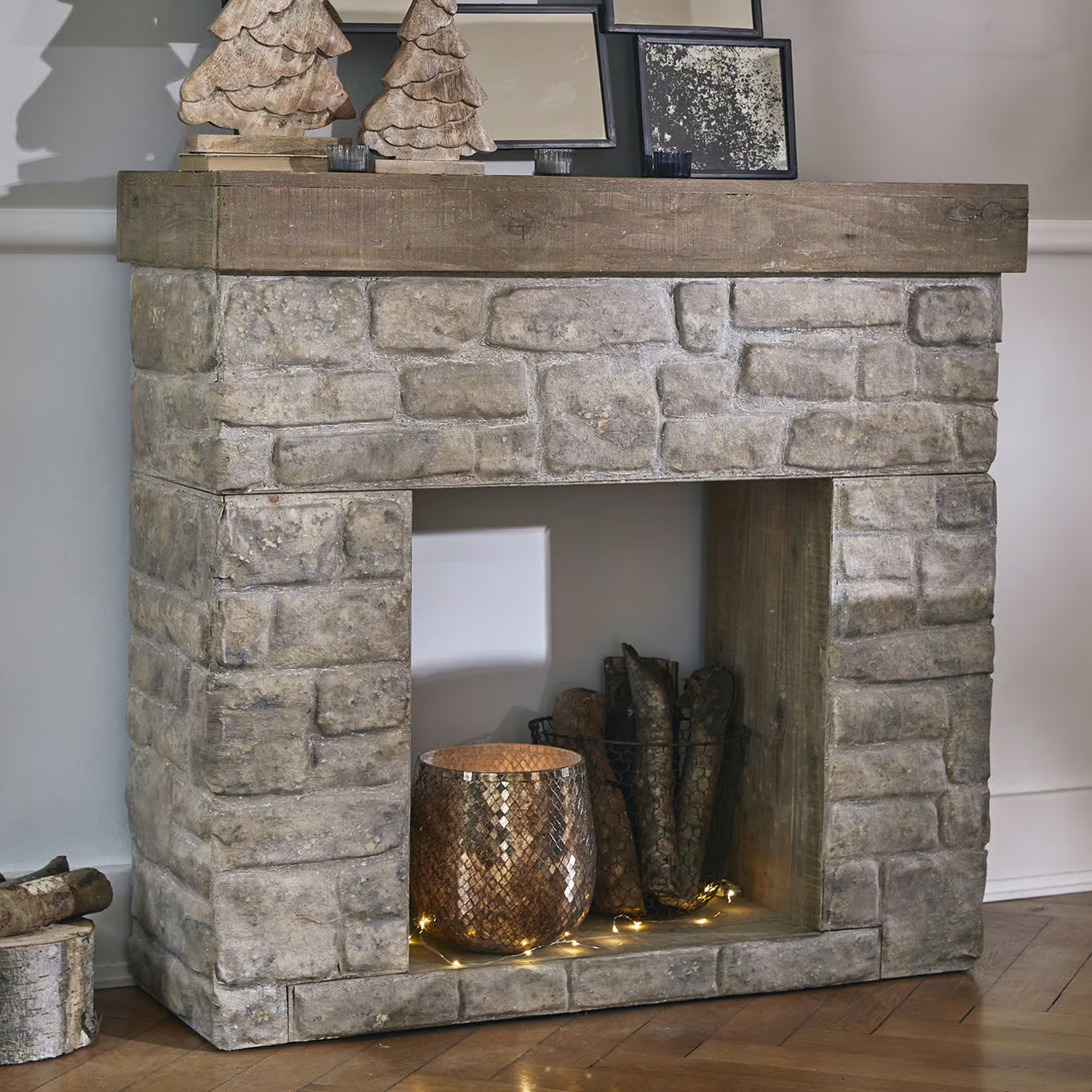 Decoratieve open haard van grijs steen en hout met siermand en LED-lichtjes binnenin