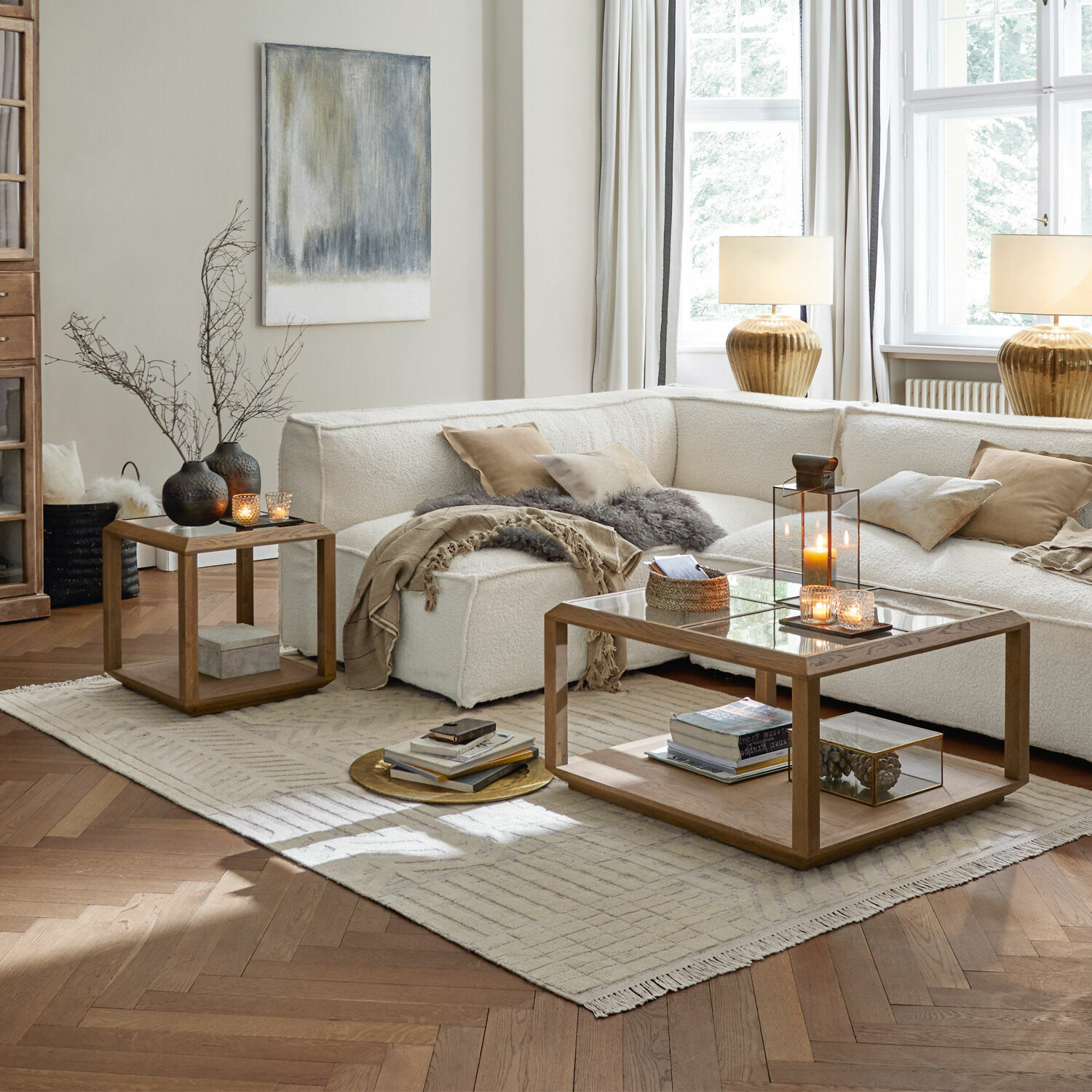 Vloerkleed Bachant Moderne woonkamer met witte bank en houten salontafels op lichte vloerkleed, decoraties en lampen