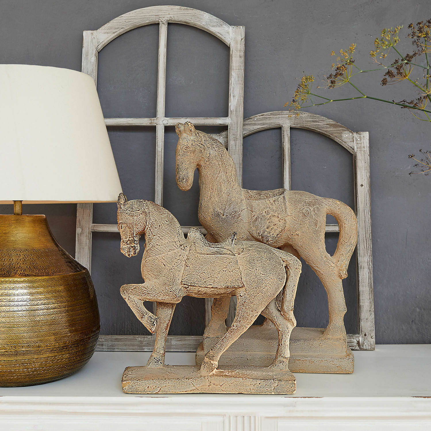 Sierpaard set van 2 Mirandel Decoratieve paardenfiguren van beige steen op een witte plank met lamp en houten raamkozijnen