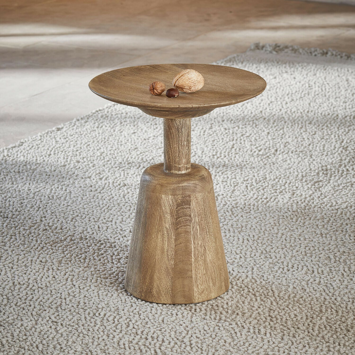 Houten bijzettafel in natuurlijke kleur op lichte vloerkleed, minimalistisch ontwerp voor woonkamer