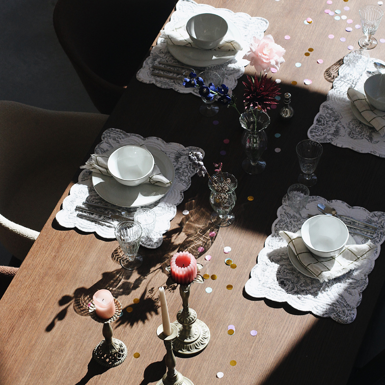 Elegant gedekte tafel met wit servies, glazen en kaarsen op houten blad