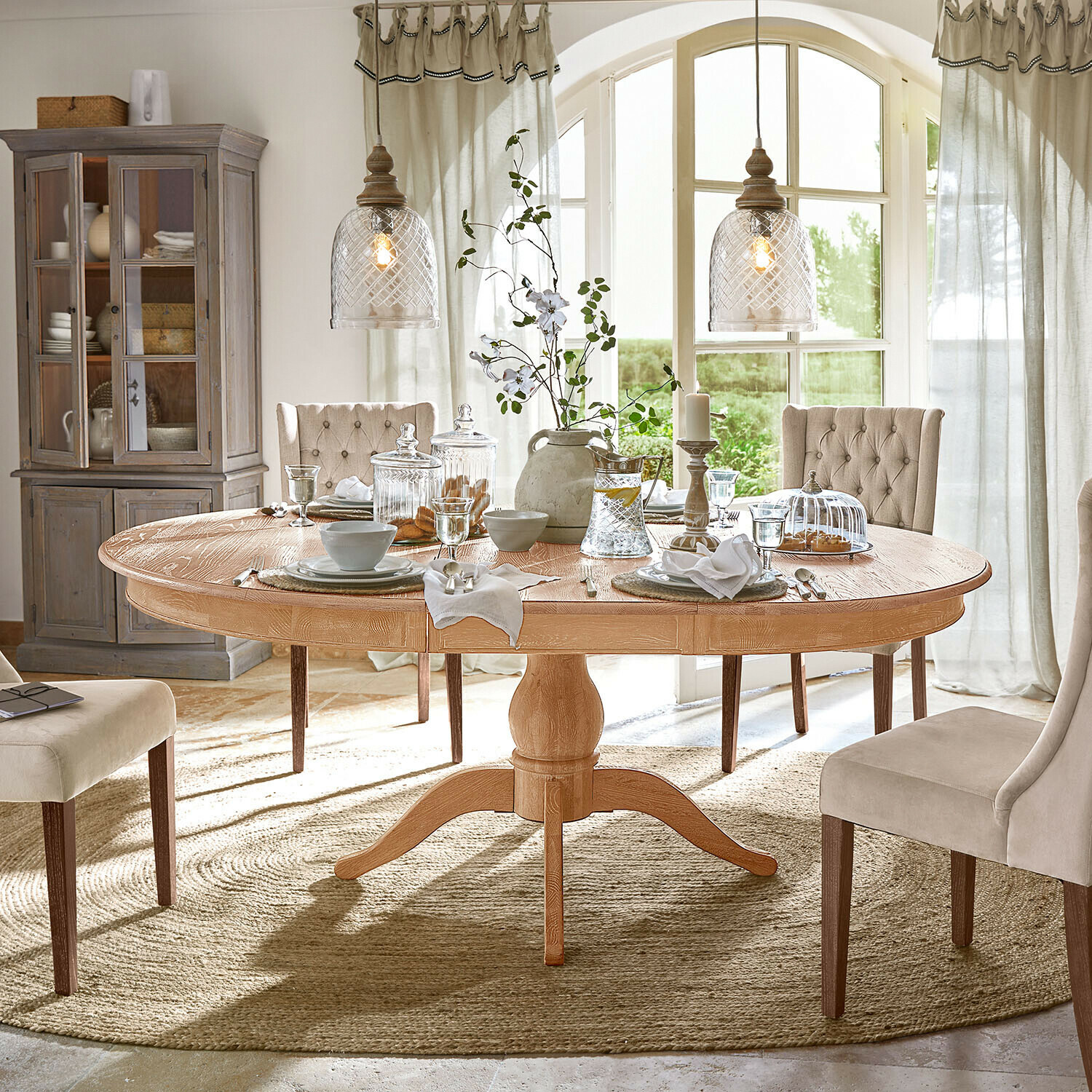Tafel Beaumont Ronde eikenhouten tafel met decoratie en bruine stoelen in een stijlvolle eetkamer