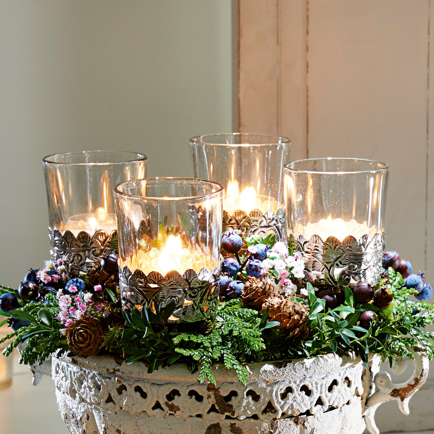 Windlicht set van 4 Pinelle Decoratieve metalen schaal in vintage stijl met vier kaarsen en groene versieringen op houten dienblad