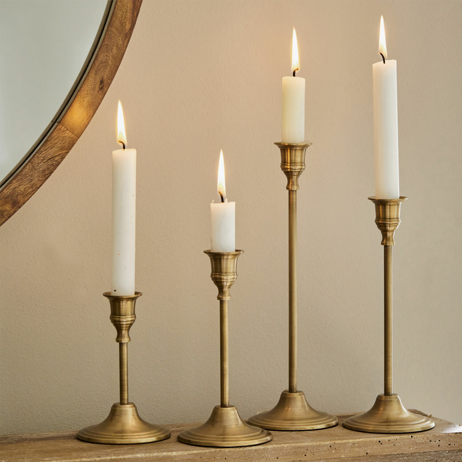 Kandelaar set van 4 Namoris Set van vier messing kandelaren met witte kaarsen op houten oppervlak, sfeervolle interieurdecoratie