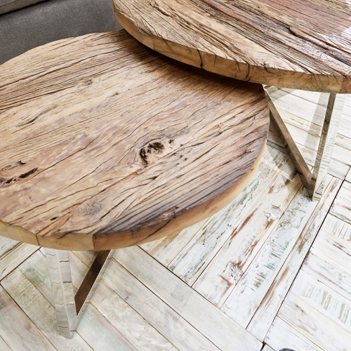 Twee ronde bijzettafels van natuurlijk hout met metalen poten op lichte vloer, moderne meubels