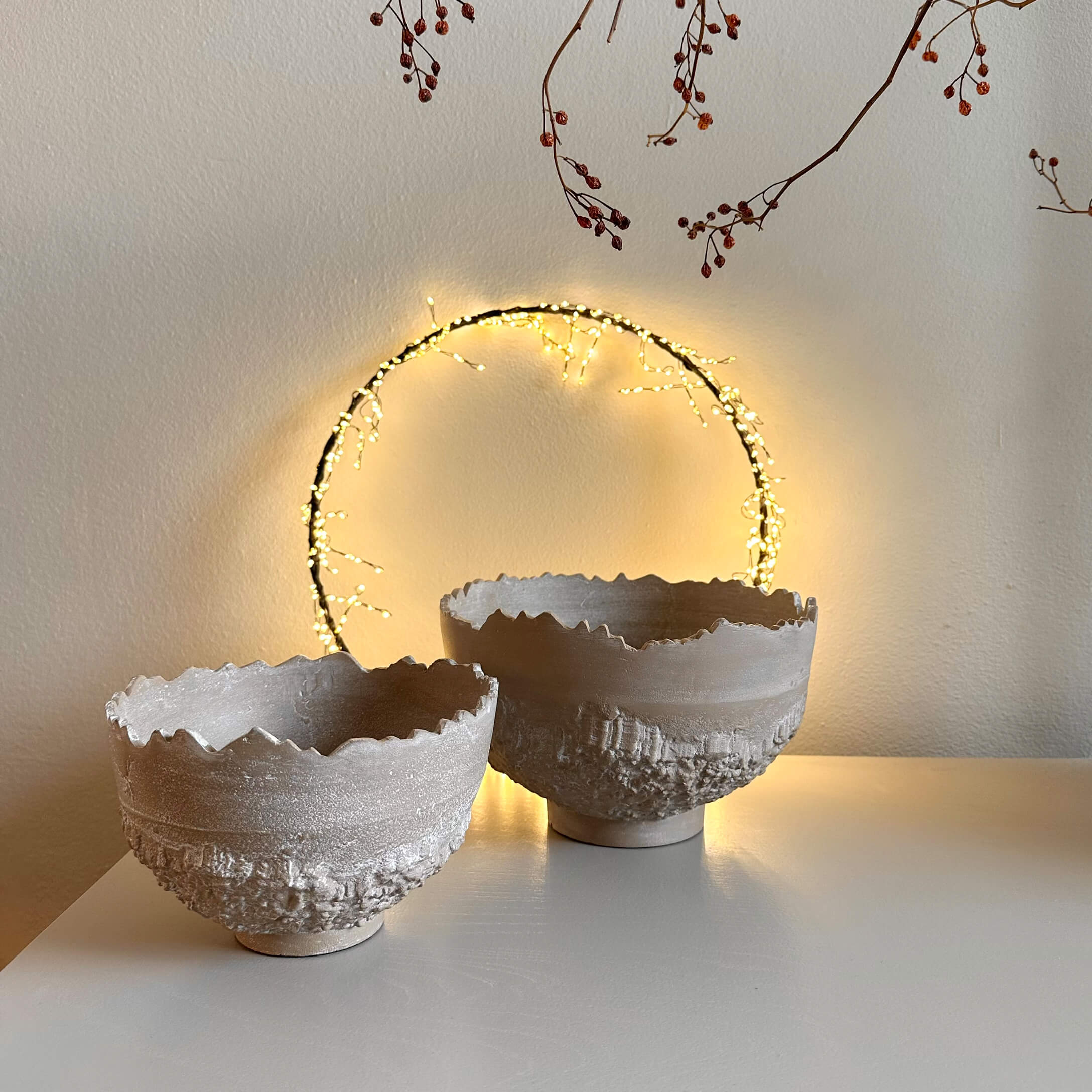 Twee decoratieve beige keramische kommen met ruwe textuur en onregelmatige rand op witte tafel