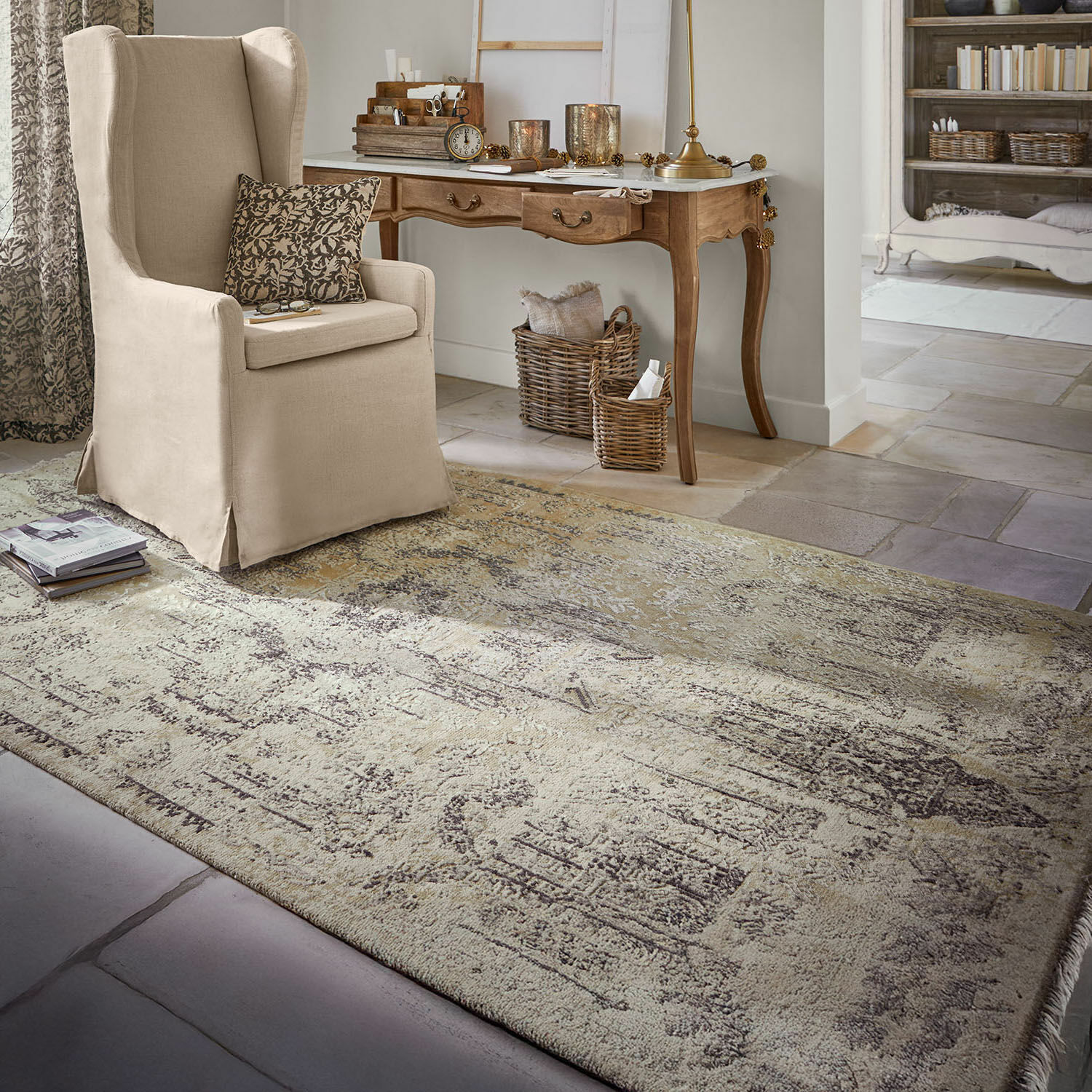 Beige vintage vloerkleed op stenen vloer in gezellige woonkamer met beige fauteuil