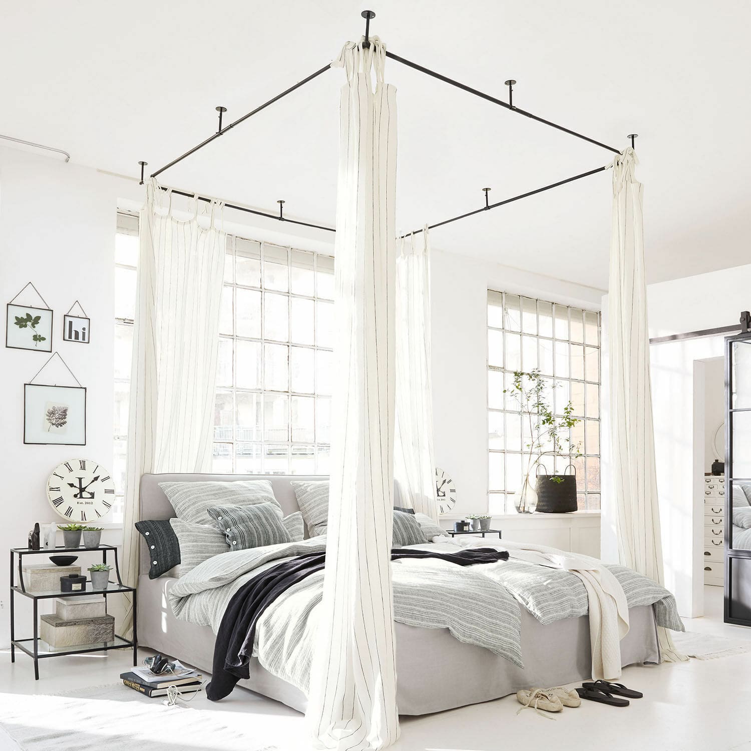 Baldakijn Giroux Modern hemelbed van lichtgrijze stof met witte gordijnen in lichte slaapkamer met grote ramen