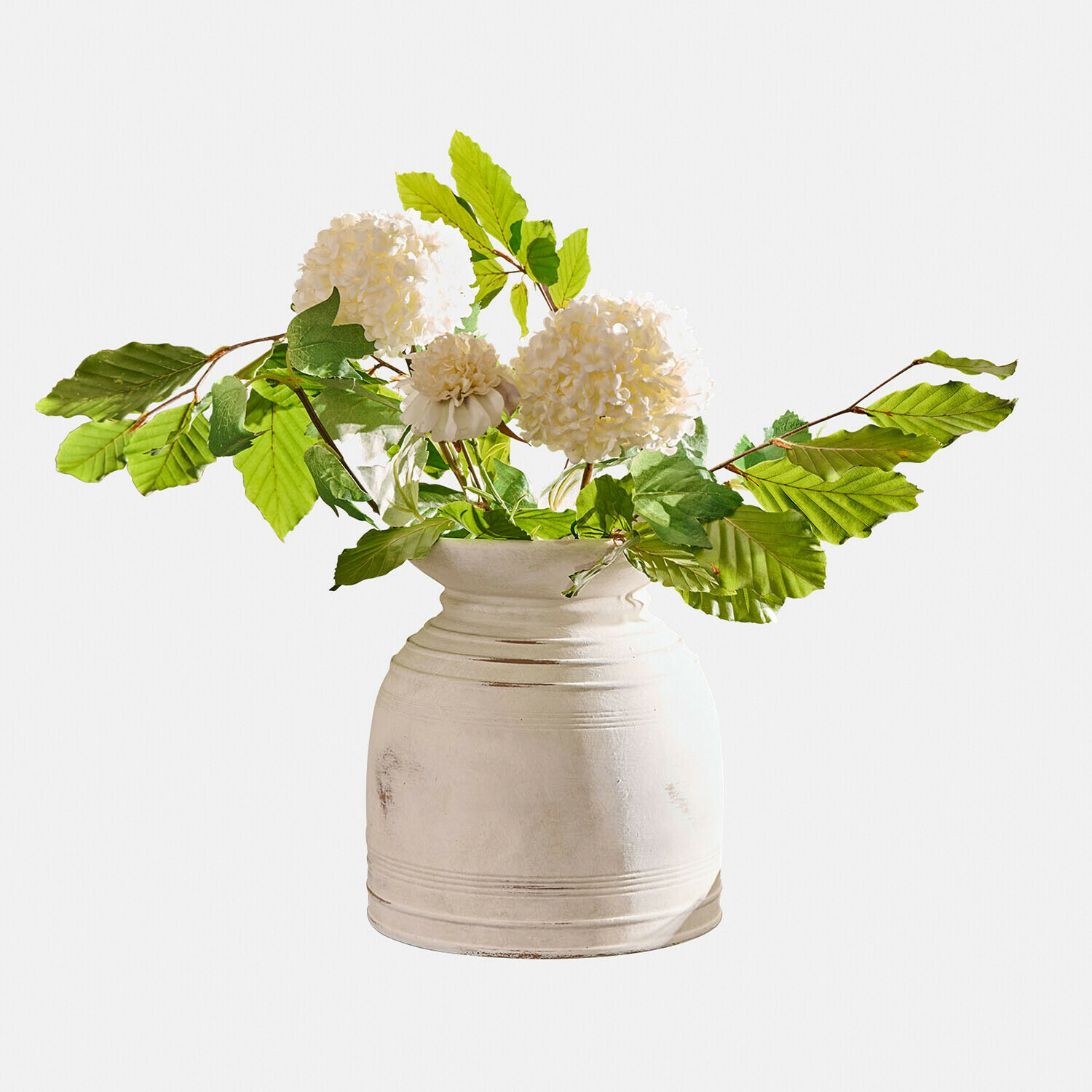 Witte keramische vaas met groene bladeren en witte decoratieve bloemen voor binnen