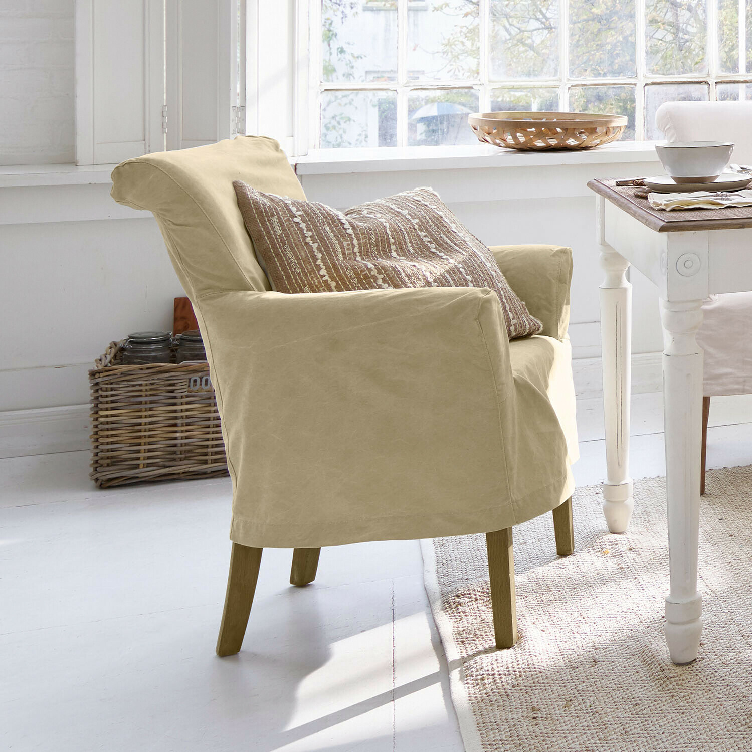 Stoel Amherst Beige stoffen fauteuil met houten poten in lichte, natuurlijke eetkamer