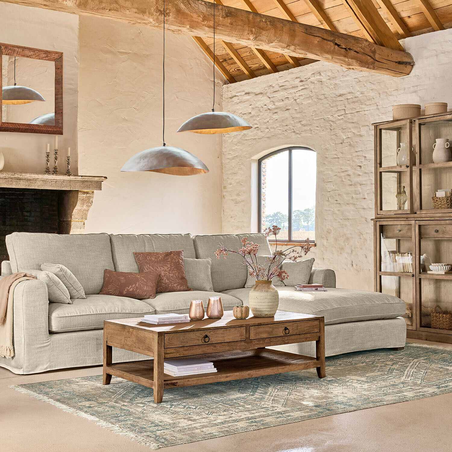 Gezellige woonkamer met beige stoffen hoekbank en houten salontafel op een decoratief vloerkleed