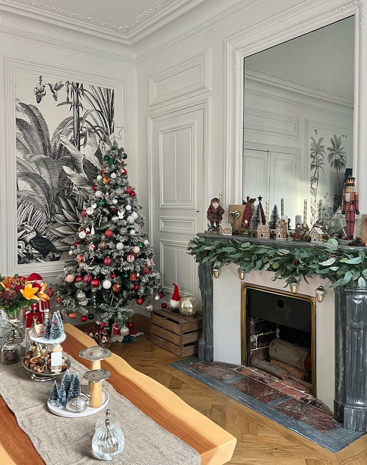 Gezellige woonkamer met witte open haard, groene krans en versierde kerstboom voor de feestdagen